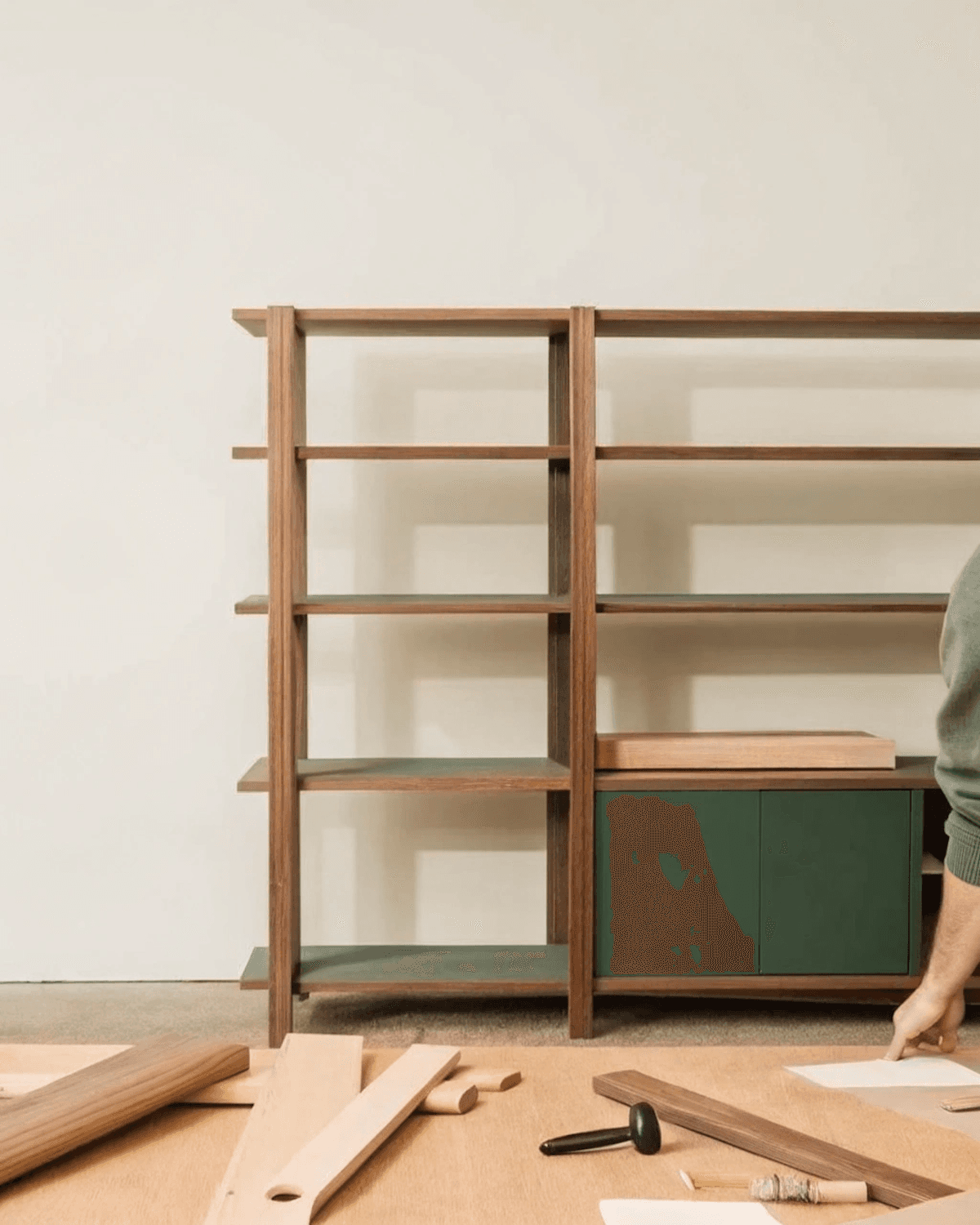 Modular oak shelving unit mid-assembly with tools and timber planks